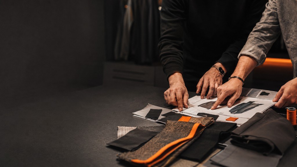 Deer Fight Gear team reviewing a tech pack, fabric swatches and trims on a studio table